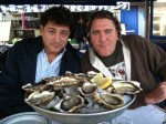 Two guys and a pile of oysters.